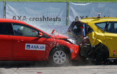 a red car crashing into a yellow one 
