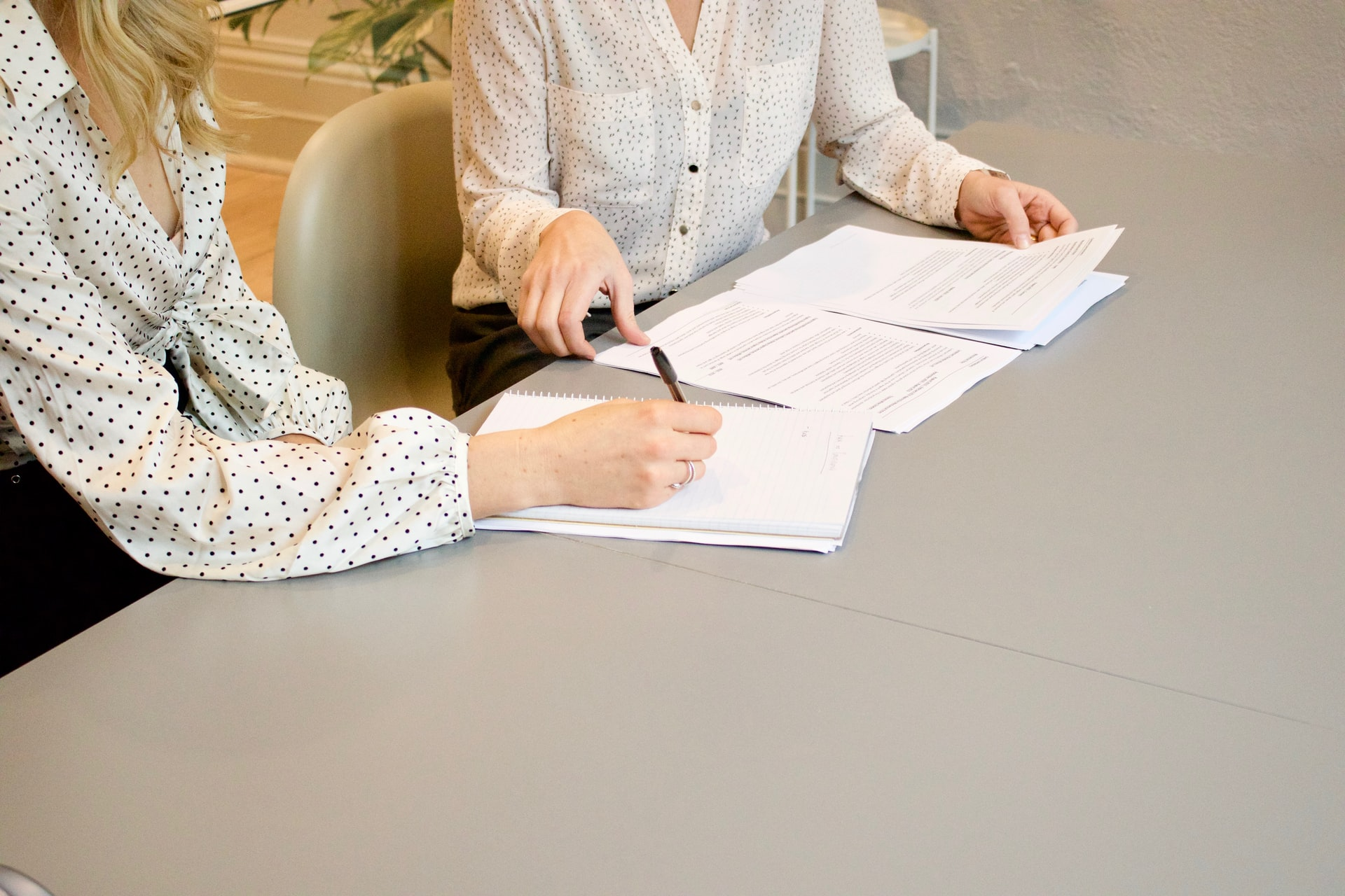 Two women signing papers
