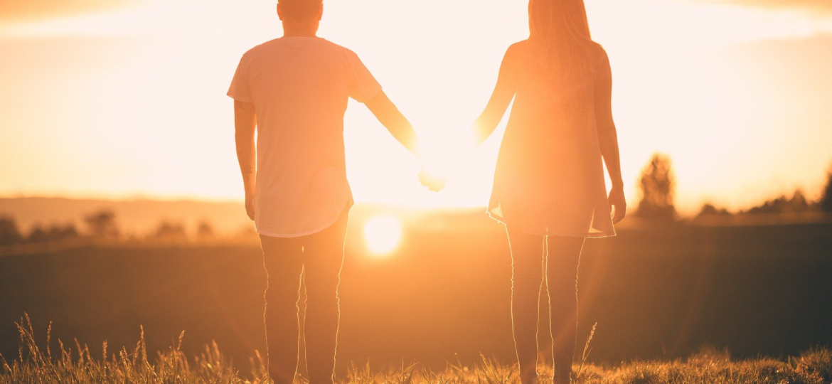 Couple holding hands watching the sunset