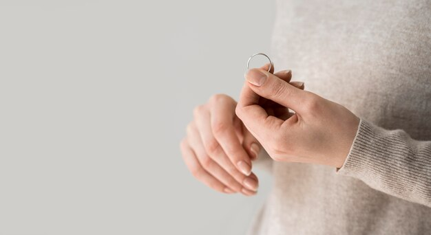 woman taking a ring off after divorce