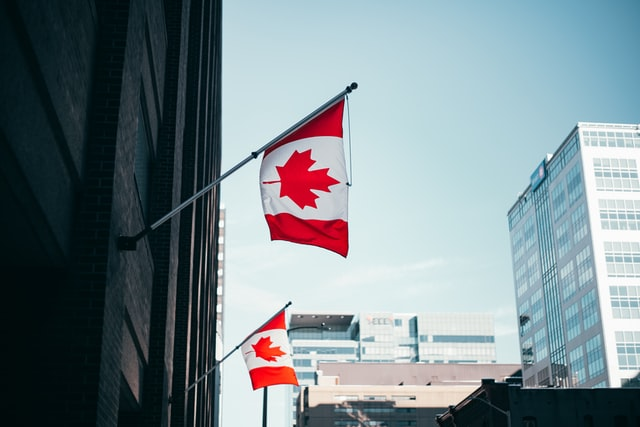 Two Canadian flags are attached to the wall