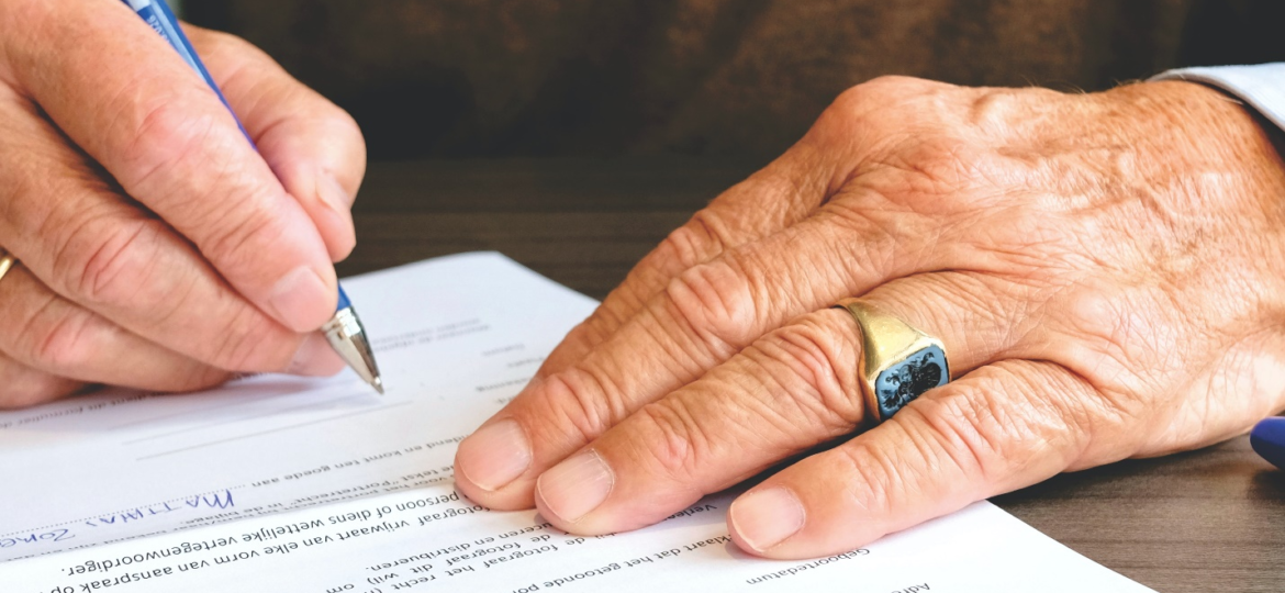 An older person signing documents