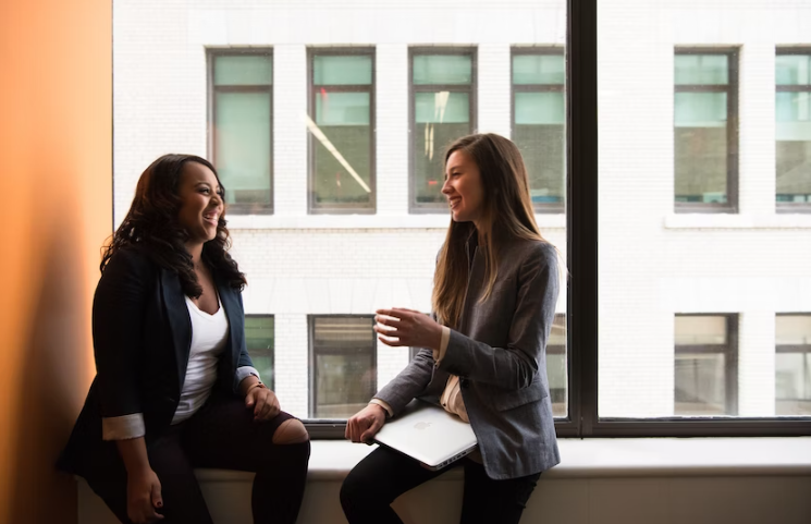 Two women chatting in a workplace