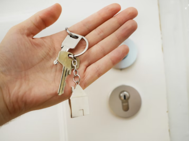 Person holding home keys.