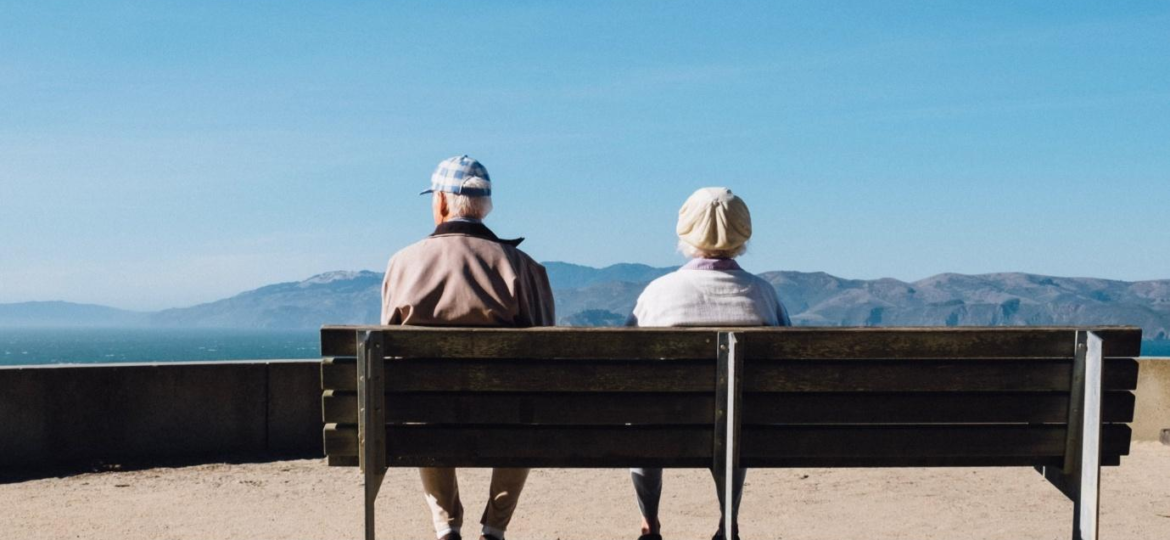 An elderly couple sitting on a bench