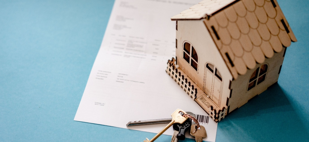 Rental document with a miniature wooden house and keys.